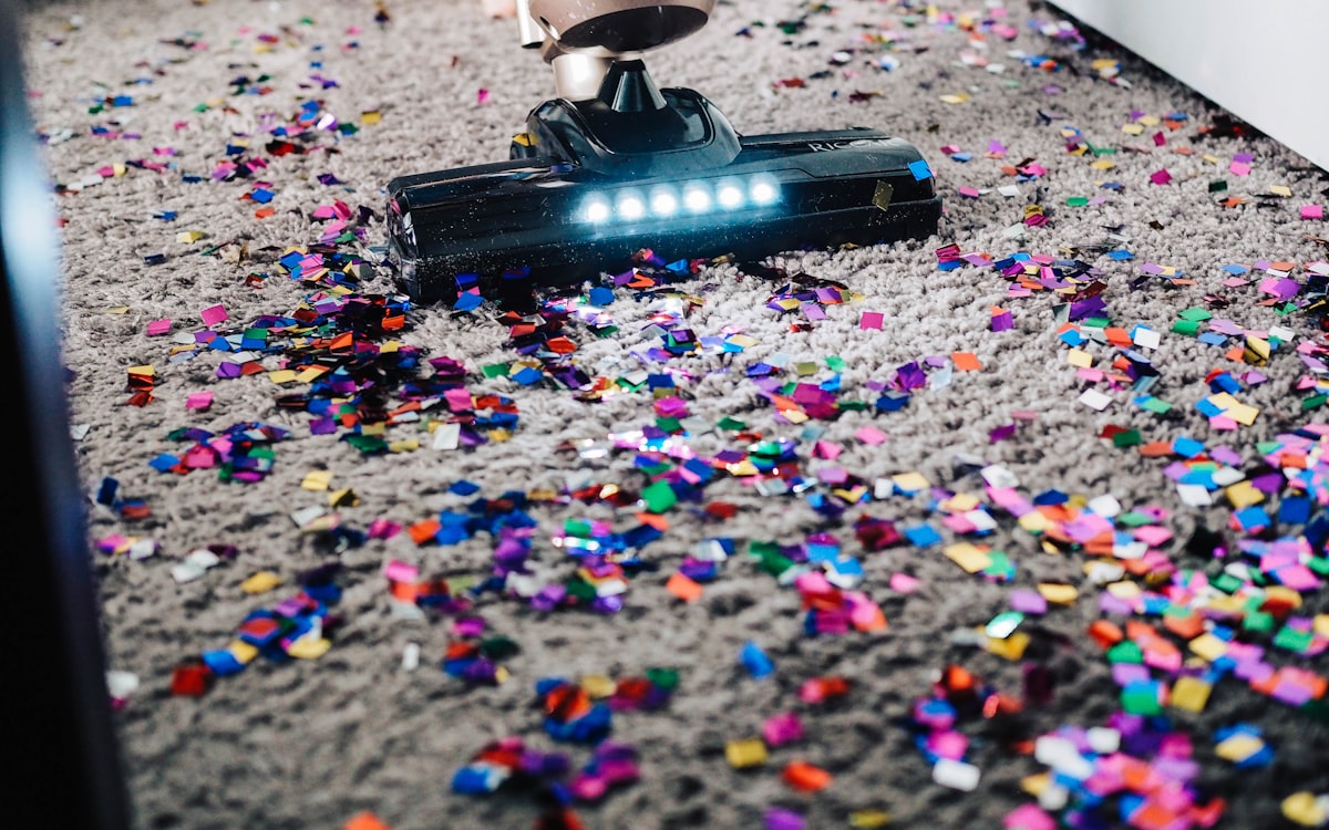 Vacuum lifting confetti and dirt out of a carpet
